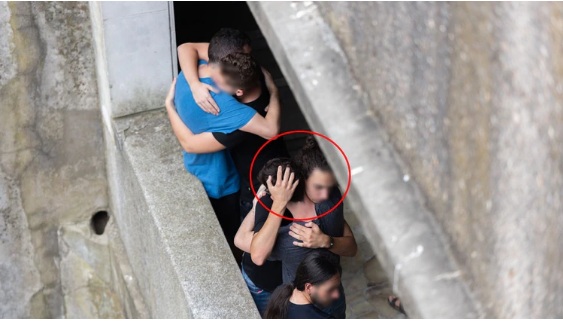 T, de pelo corto de espaldas en el funeral